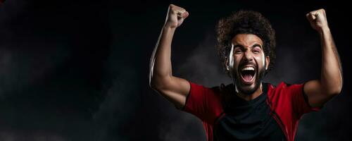 Egyptian football fan celebrating a victory on red white and black background with empty space for text photo