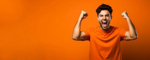 American football fan celebrating a victory on orange background with empty space for text photo