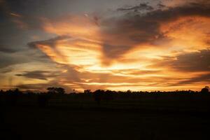 Glowing gold, orange-red, cloudy sky at sunset. Wallpaper concept. photo