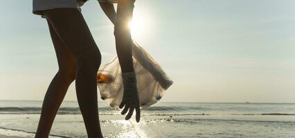 ahorrar agua. los voluntarios recogen basura en la playa y las botellas de plástico son difíciles de descomponer para evitar dañar la vida acuática. tierra, ambiente, planeta verde, reducir el calentamiento global, salvar el mundo foto