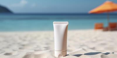 Blank empty white plastic tube. Sunscreen lotion on a sandy beach, summer composition with sunglasses, blue sea as background, copy space. Summer vacation and skin care concept, photo