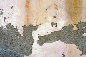 Old rough concrete wall covered with peeled dirty white paint. Abstract textured background. photo