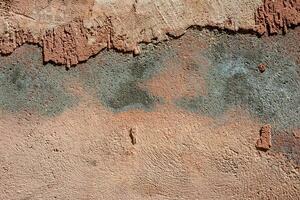 Damaged cracked brown plaster wall. Abstract background. photo