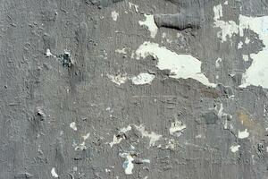 Gray painted torn posters on a wall close up texture background photo
