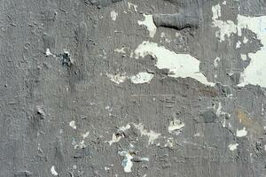 Gray painted torn posters on a wall close up texture background photo