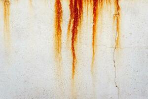 Grunge textured background with rust stains on an old beige cracked wall photo