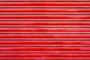 Textured background of red wooden roller shutter door close up photo