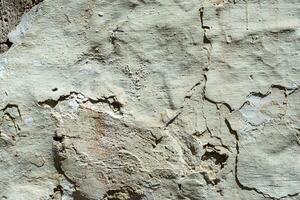 Grey rough cracked plaster wall abstract background. photo