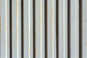 Close up image of a painted corrugated metal sheet with rusty spots. Industrial background. photo