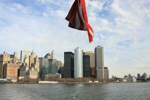 Skyline of New York City with the American Flag waving in the foreground photo