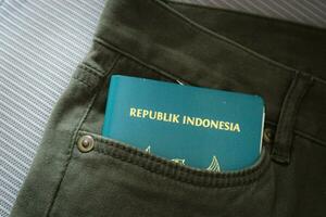 un indonesio ciudadanía pasaporte en un verde mezclilla bolsillo. foto