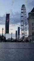 hermosa bajo ángulo imágenes de turista personas son caminando a lo largo ruta de Londres ojo a Westminster central Londres ciudad de Inglaterra genial Bretaña, imágenes estaba capturado en ago 02, 2023 durante puesta de sol. video