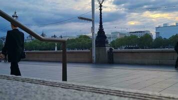 bellissimo Basso angolo metraggio di turista persone siamo a piedi lungo sentiero di Londra occhio a Westminster centrale Londra città di Inghilterra grande Gran Bretagna, metraggio era catturato su ago 02, 2023 durante tramonto. video