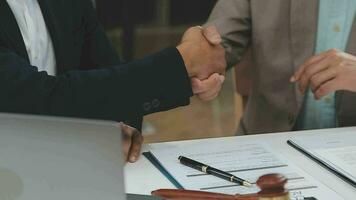 Business and lawyers discussing contract papers with brass scale on desk in office. Law, legal services, advice, justice and law concept picture with film grain effect video