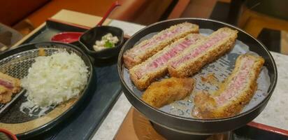 Indonesian japanese fusion food, japanese food cook in indonesian style, gyukatsu, beef karage, salad, and tofu soup photo