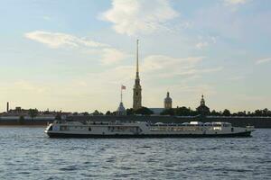 St. Petersburg, Russia. Ship with tourists crossing the Neva River in front of the Peter and Paul Fortress. photo