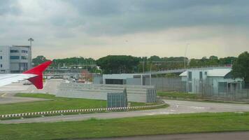 CHANGI, SINGAPORE NOVEMBER 22, 2018  - Terminal 4 in Changi Airport view from taxiing airplane AirAsia, airplanes parked near terminal. video