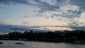 maggior parte bellissimo metraggio di illuminato Londra occhio a partire dal fiume Tamigi Westminster, grande Ben orologio Torre a dopo tramonto notte. Inghilterra grande Gran Bretagna, metraggio era catturato su ago 02, 2023 durante tramonto. video