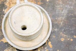 Top view of ancient stone flour mill on black wooden table. photo