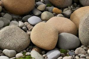 grandes piedras de diferentes formas en el primer plano de la orilla del río. hay muchas piedras pequeñas cerca. foto