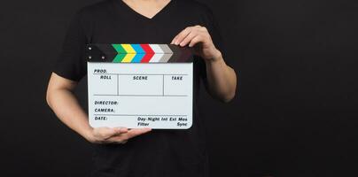 Hand is holding movie slate.It is used in video production and film industry on black background. photo