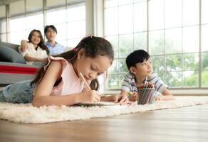 A boy and a daughter from an asian family. The children are having fun in the art of drawing. photo