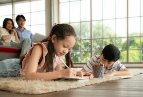 A boy and a daughter from an asian family. The children are having fun in the art of drawing. photo