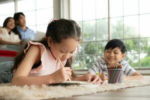 A boy and a daughter from an asian family. The children are having fun in the art of drawing. photo