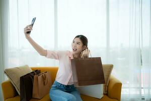 contento asiático mujer tomando selfie con compras bolso en el de la tienda VIP salón foto