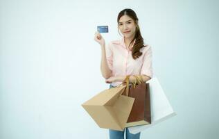 Happy woman holding shopping bags and credit card isolated on white background. photo