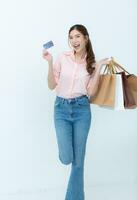 Happy woman holding shopping bags and credit card isolated on white background. photo