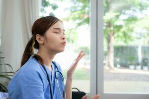 A female nurse is eating a fried potatoes of bread in her office. photo