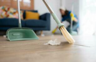 Cleaning service. Dark-haired woman wearing a white hat and yellow gloves cleaning the floor photo