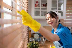 Asian young woman cleaning window in the kitchen. housework concept photo