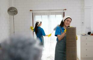 Asian young woman cleaning window in the living room. housework concept photo