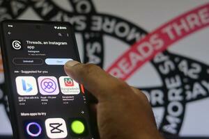 installing Threads app on a phone, The threads logo is displayed on a smartphone screen. Threads new social network, Say More Campaign by Threads, Threads Instagram, July 20, 2023 - Dhaka, Bangladesh photo