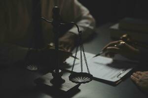 Business and lawyers discussing contract papers with brass scale on desk in office. Law, legal services, advice, justice and law concept picture with film grain effect photo