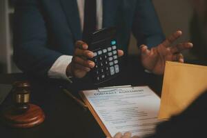 Business and lawyers discussing contract papers with brass scale on desk in office. Law, legal services, advice, justice and law concept picture with film grain effect photo