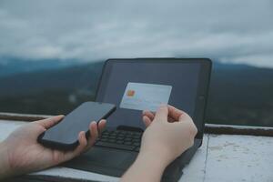 online payment, young woman holding credit card and typing on laptop photo