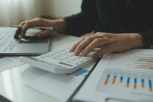 Unrecognizable businessman using calculator photo