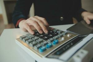 Unrecognizable businessman using calculator photo
