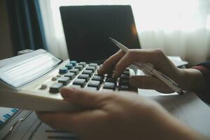Unrecognizable businessman using calculator photo