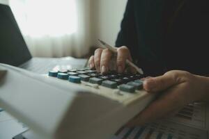 Unrecognizable businessman using calculator photo