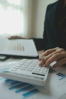 Unrecognizable businessman using calculator photo