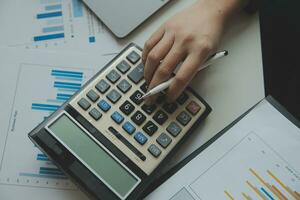 Unrecognizable businessman using calculator photo