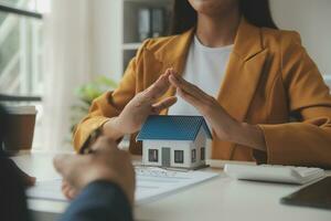 Real estate brokerage agent Deliver a sample of a model house to the customer, mortgage loan agreement Making lease and buy and sell house And contract home insurance mortgage loan concept photo
