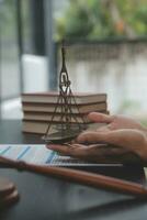 Business and lawyers discussing contract papers with brass scale on desk in office. Law, legal services, advice, justice and law concept picture with film grain effect photo