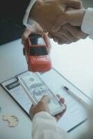 Closeup asian male people car salesman or sales manager offers to sell a car and explains and reads the terms of signing a car contract and insurance. photo