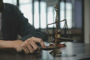 Business and lawyers discussing contract papers with brass scale on desk in office. Law, legal services, advice, justice and law concept picture with film grain effect photo