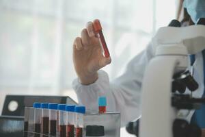 Professional lab. Amazing longhaired medical worker wearing uniform while using microscope during research photo
